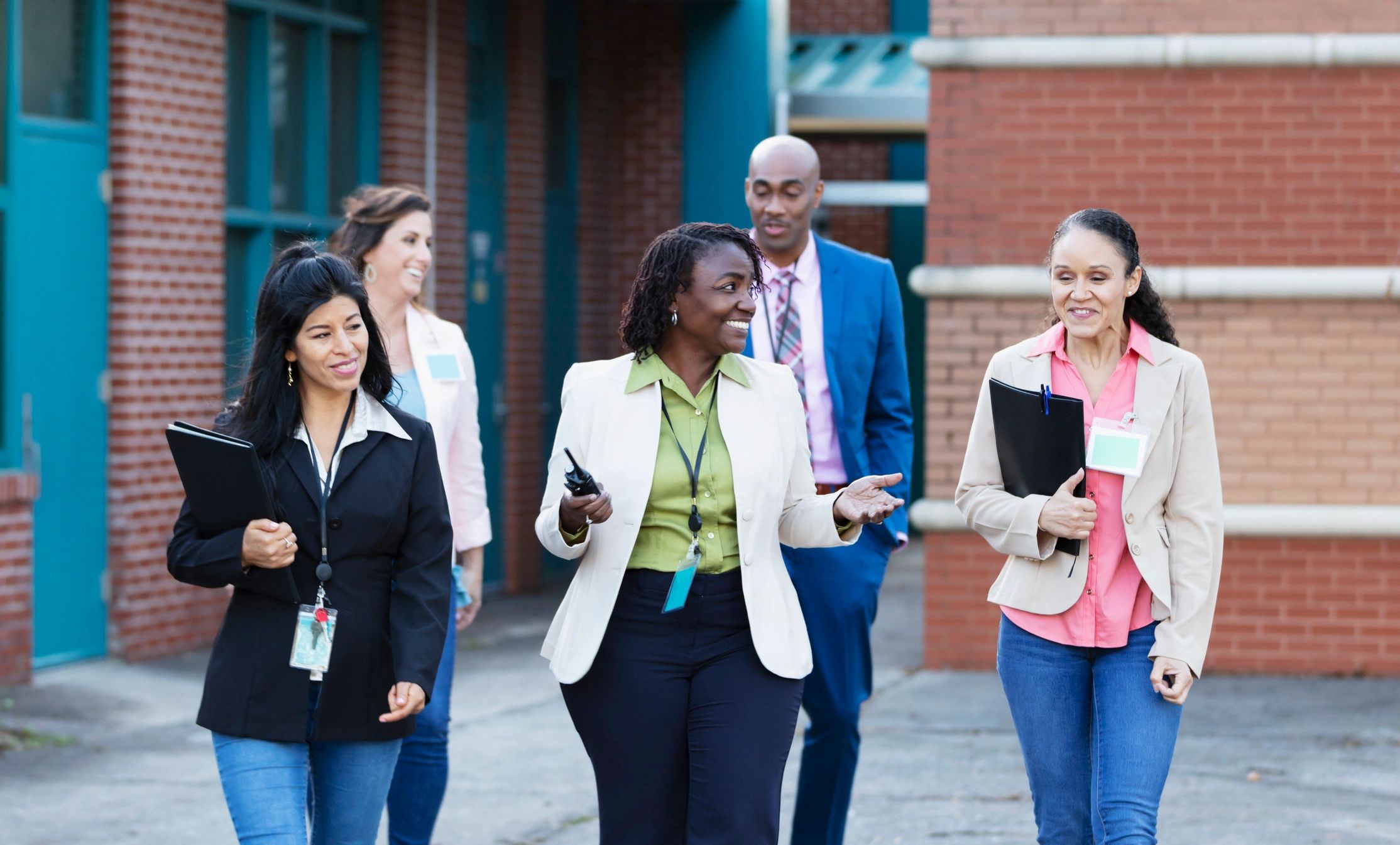Group of educators walking together outside a school building