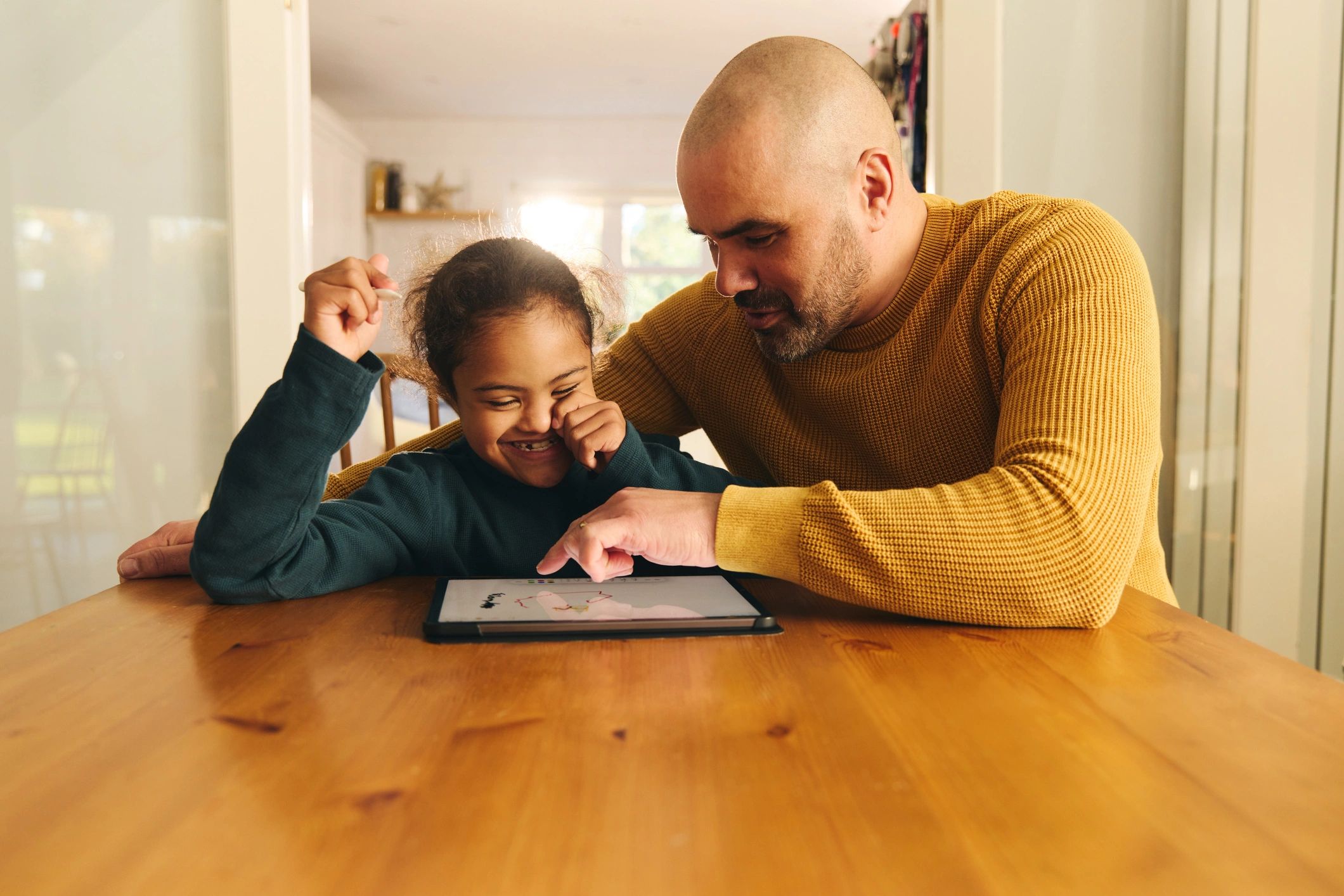 Father and son using a digital tablet together for learning at home