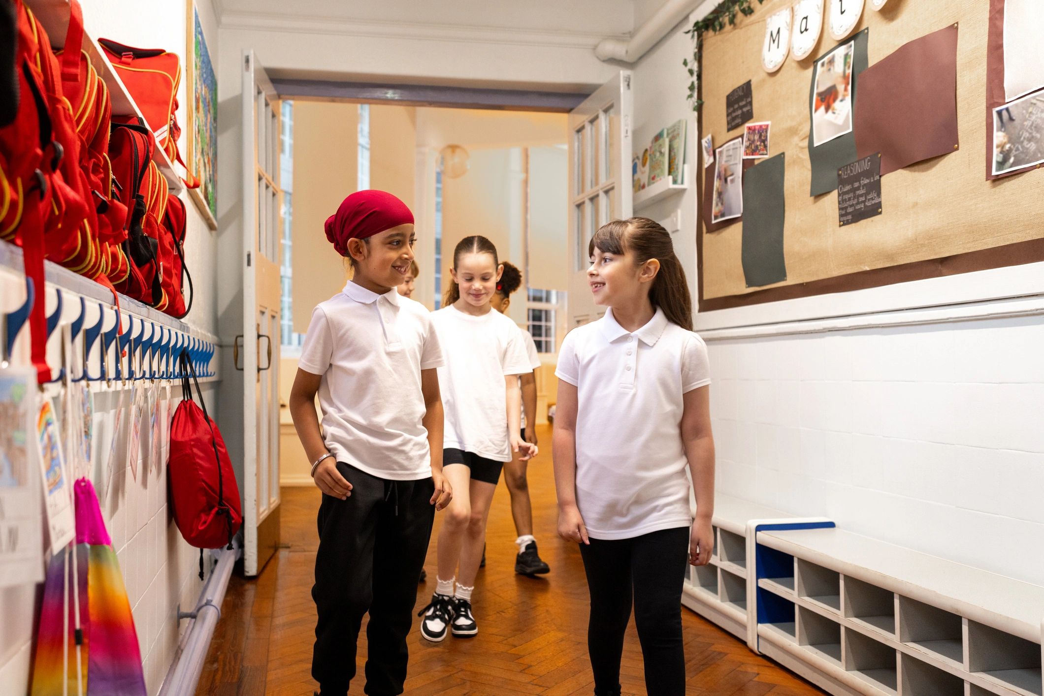 Schoolchildren walking through a bright school hallway