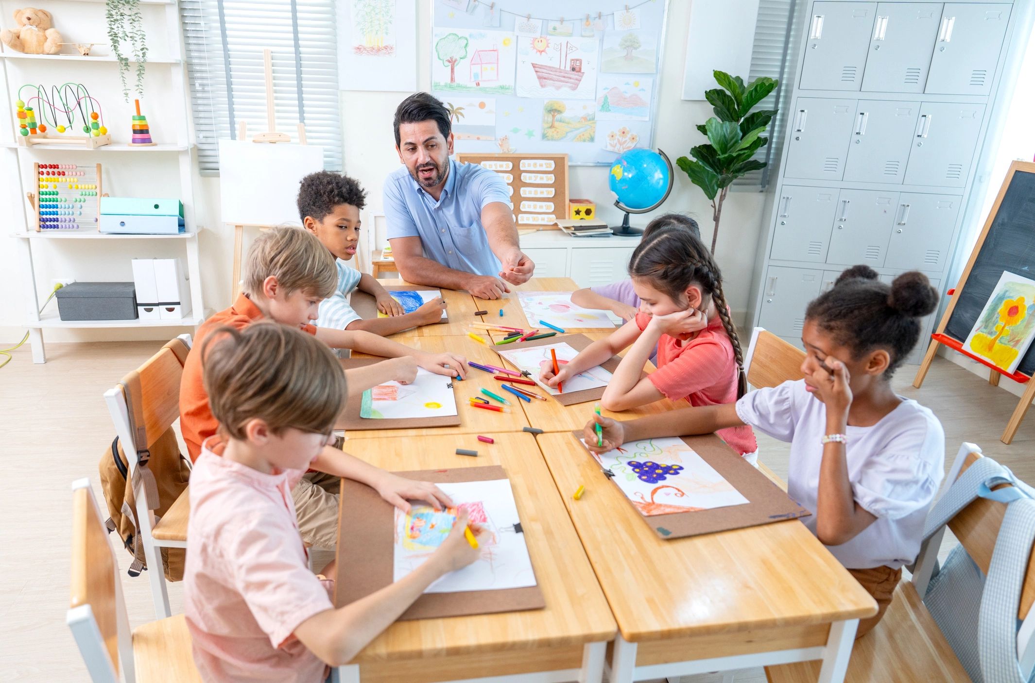 Teacher guiding children in a classroom art activity